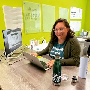 Alison Farone working on a design project at her desk at Kiwi Creative